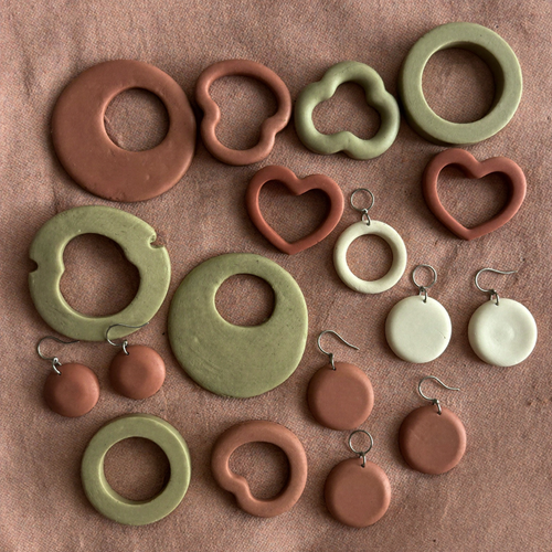 Terracotta and sage clay earring cutters with finished polymer clay earrings on linen